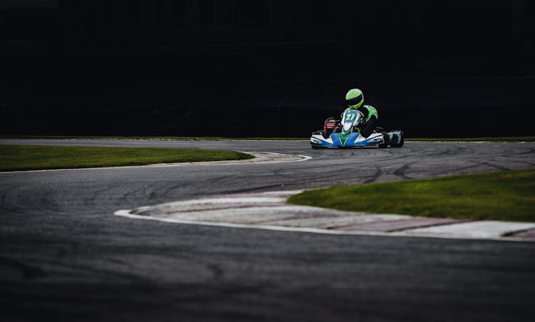 Man Wearing Green Helmet Riding Go Kart