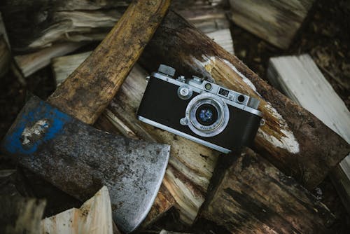 Macchina Fotografica Nera E Grigia Vicino All'ascia