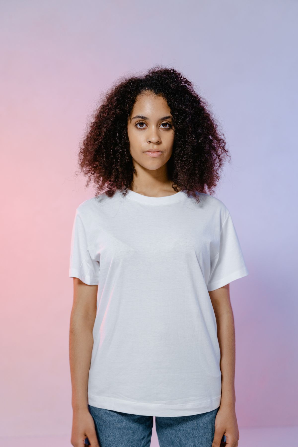 Person wearing a plain white t-shirt against a colourful background