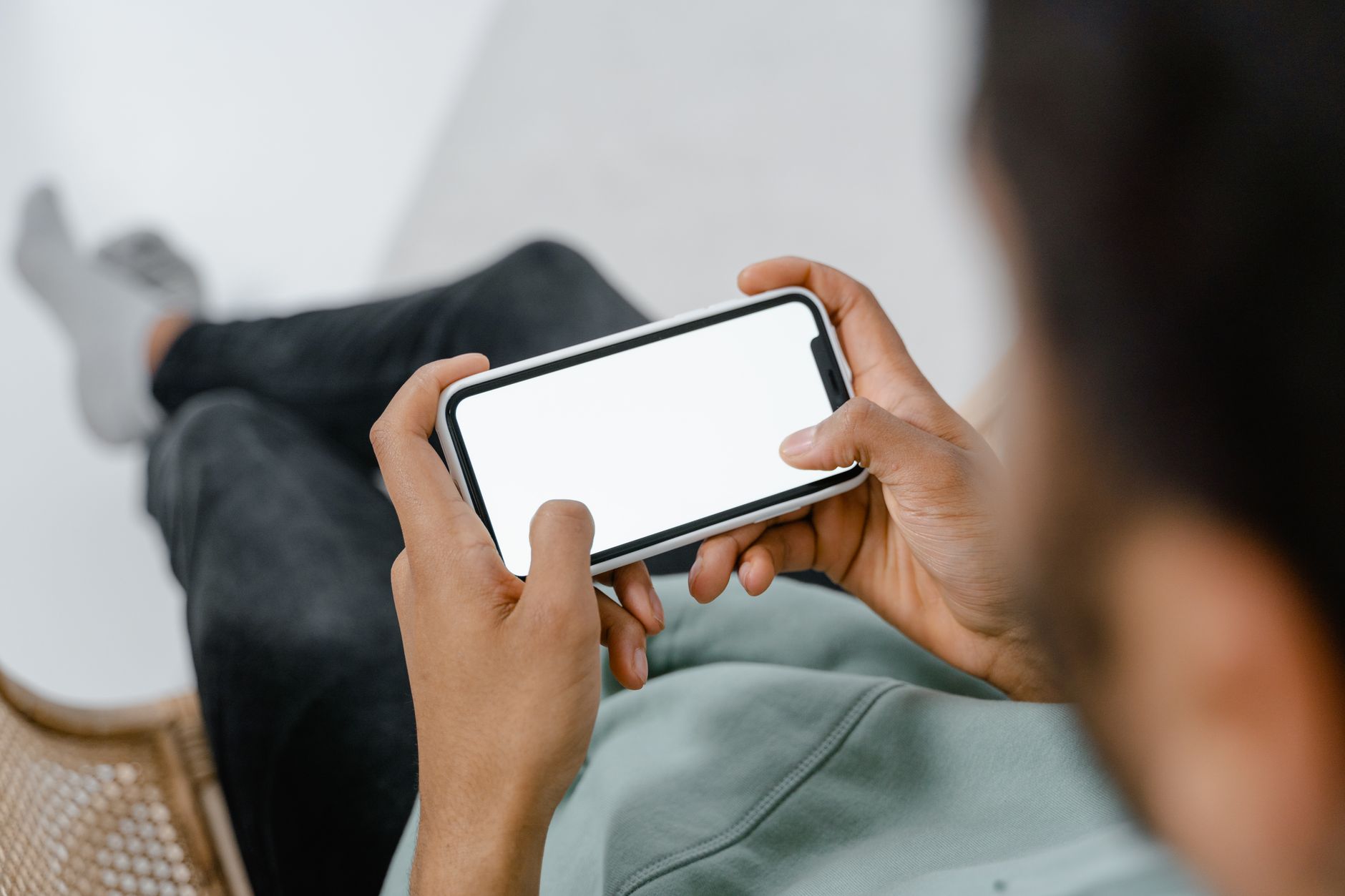 Person holding a smartphone with a blank screen, ideal for mockups.