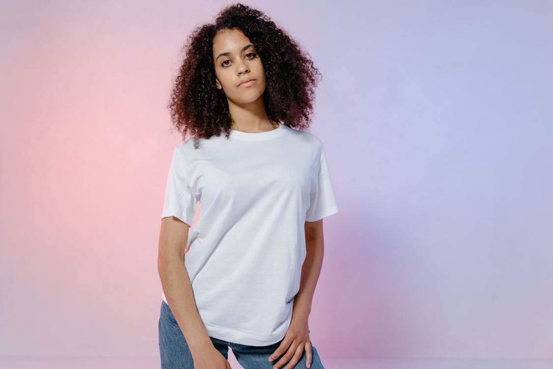 Woman Wearing a White Crew Neck T-shirt and Denim Pants · Free Stock Photo