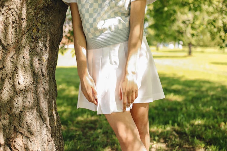 A Woman Wearing A White Skirt Under The Shade Of A Tree