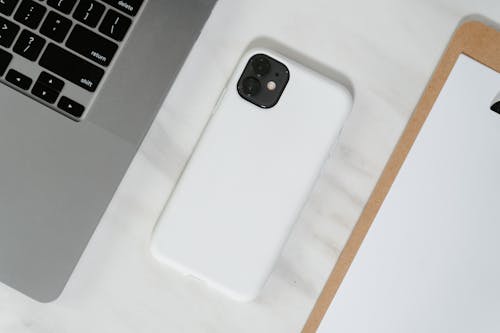 Free Close-Up Shot of a Smartphone beside a Laptop Stock Photo