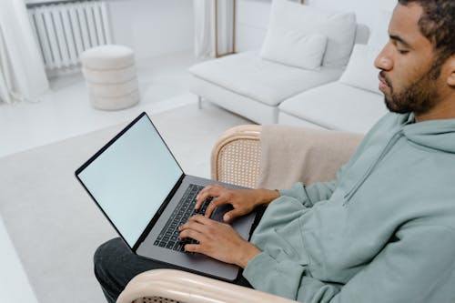 A Man Typing on a Laptop