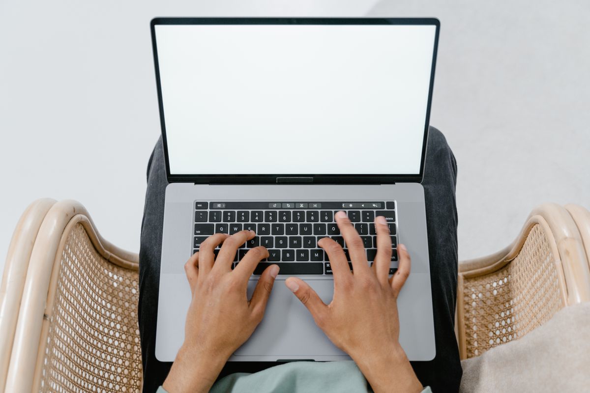Đôi tay gõ phím trên laptop nhìn từ trên xuống