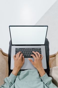 Top view of someone using a laptop with a blank screen, perfect for mockup and tech concepts.