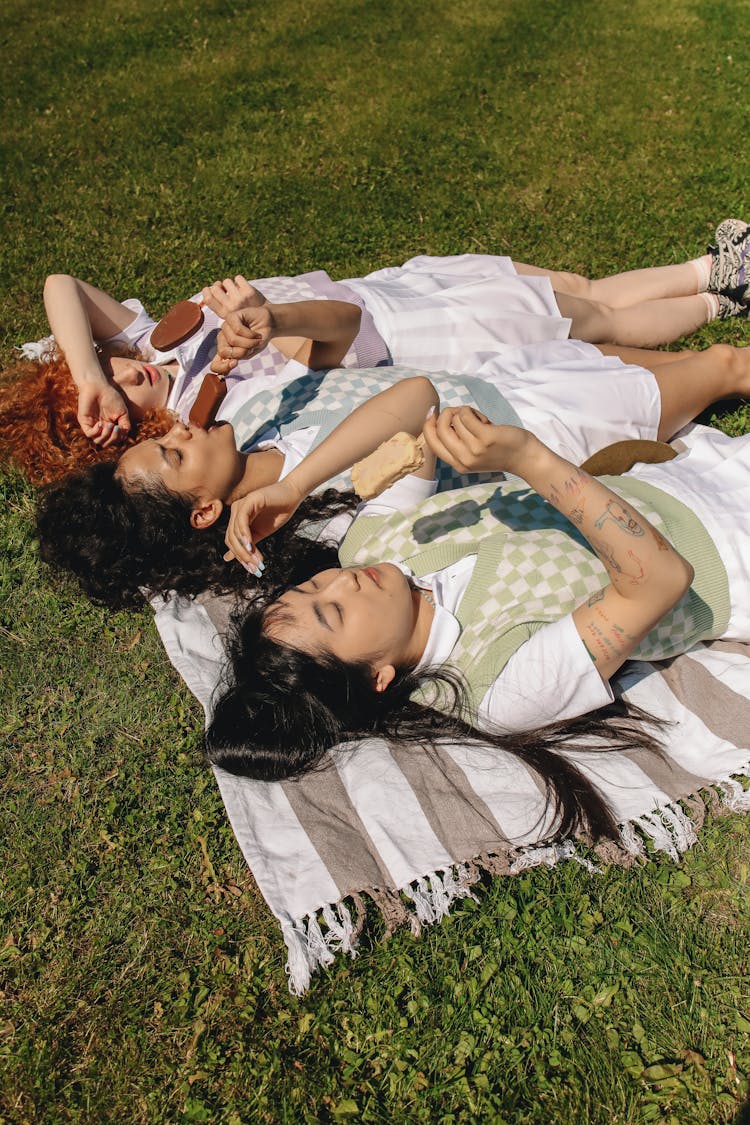 Women Lying On The Grass While Eating Ice Cream