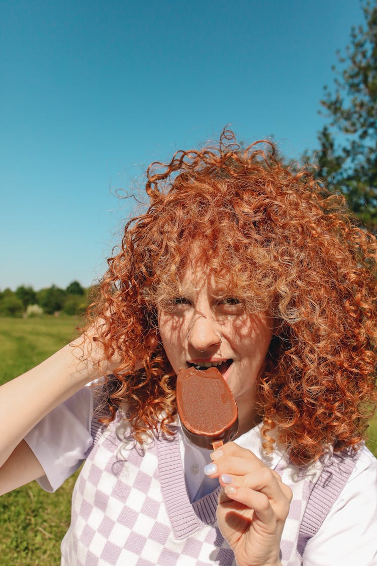 Woman In Sweater Vest Eating Ice Cream