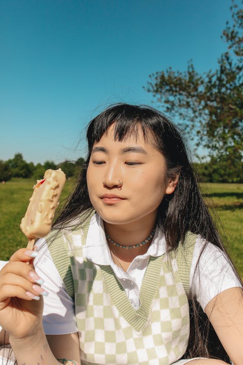Young Woman in Checked Vest Holding Ice Cream