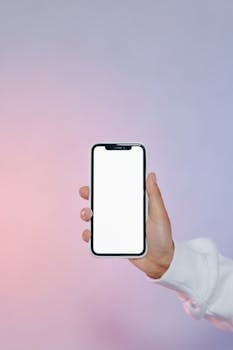 Hand holding a smartphone with a blank white screen for design mockup, ideal for presentations.