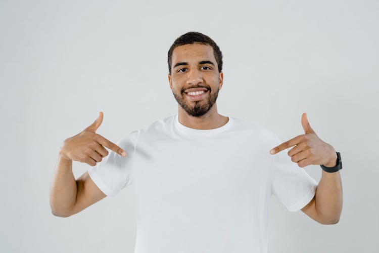 A Bearded Man Pointing At His Plain White Shirt