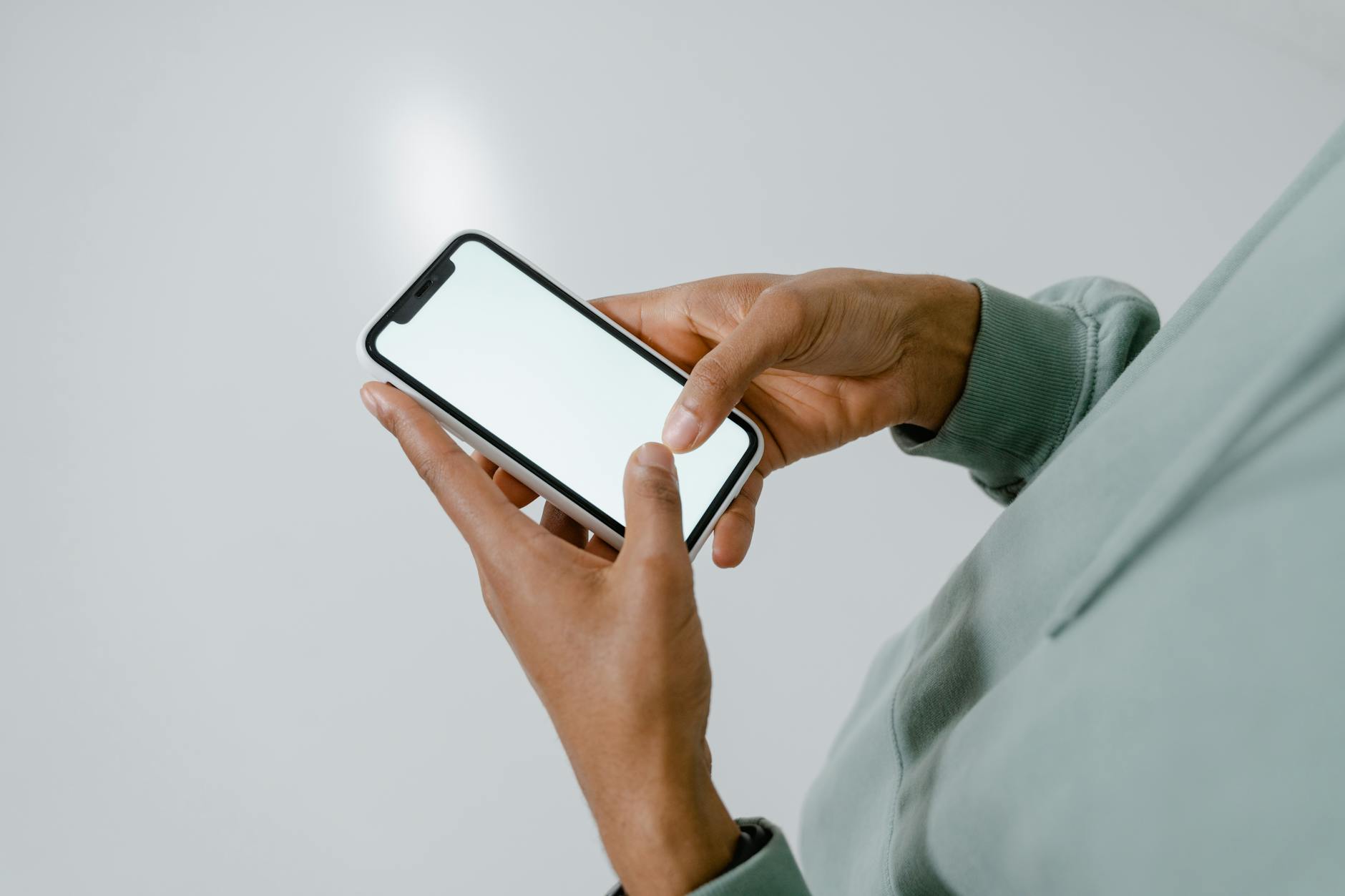 A Person Holding an iPhone with a Blank Screen