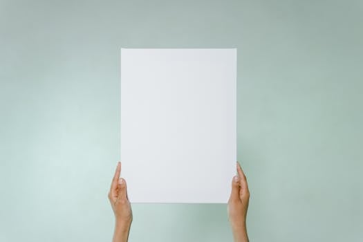 Simple blank canvas held hands on light green background with copy space.
