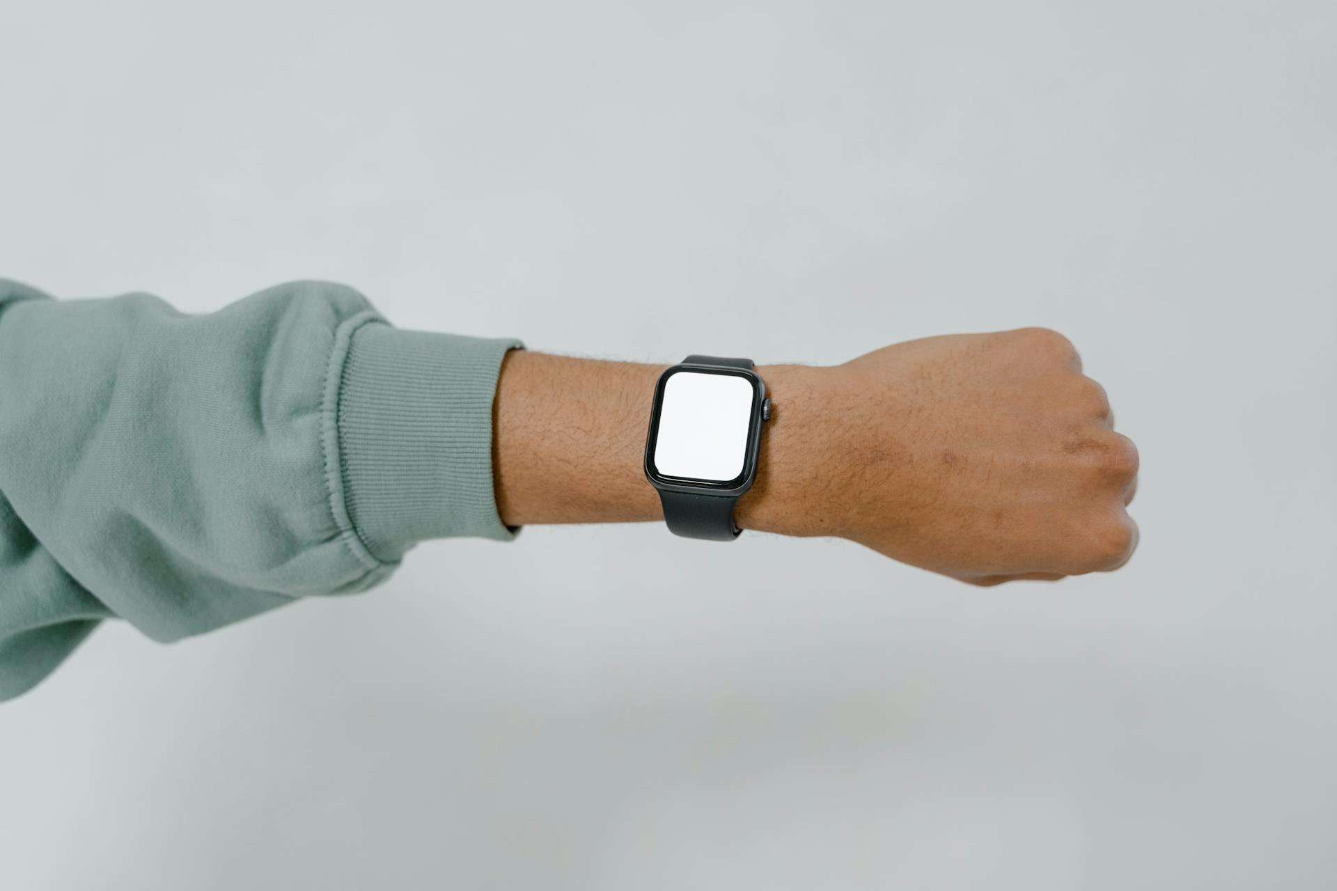 Person Wearing Silver Aluminum Case Apple Watch With White Sport Band