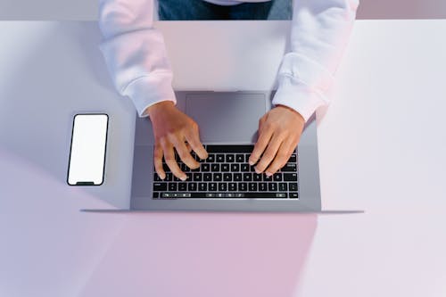 Free Person in White Long Sleeve Shirt Using Laptop  Stock Photo