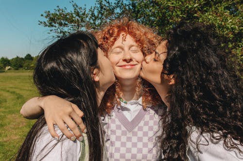 Photograph of Girls Kissing Their Friend on the Cheek