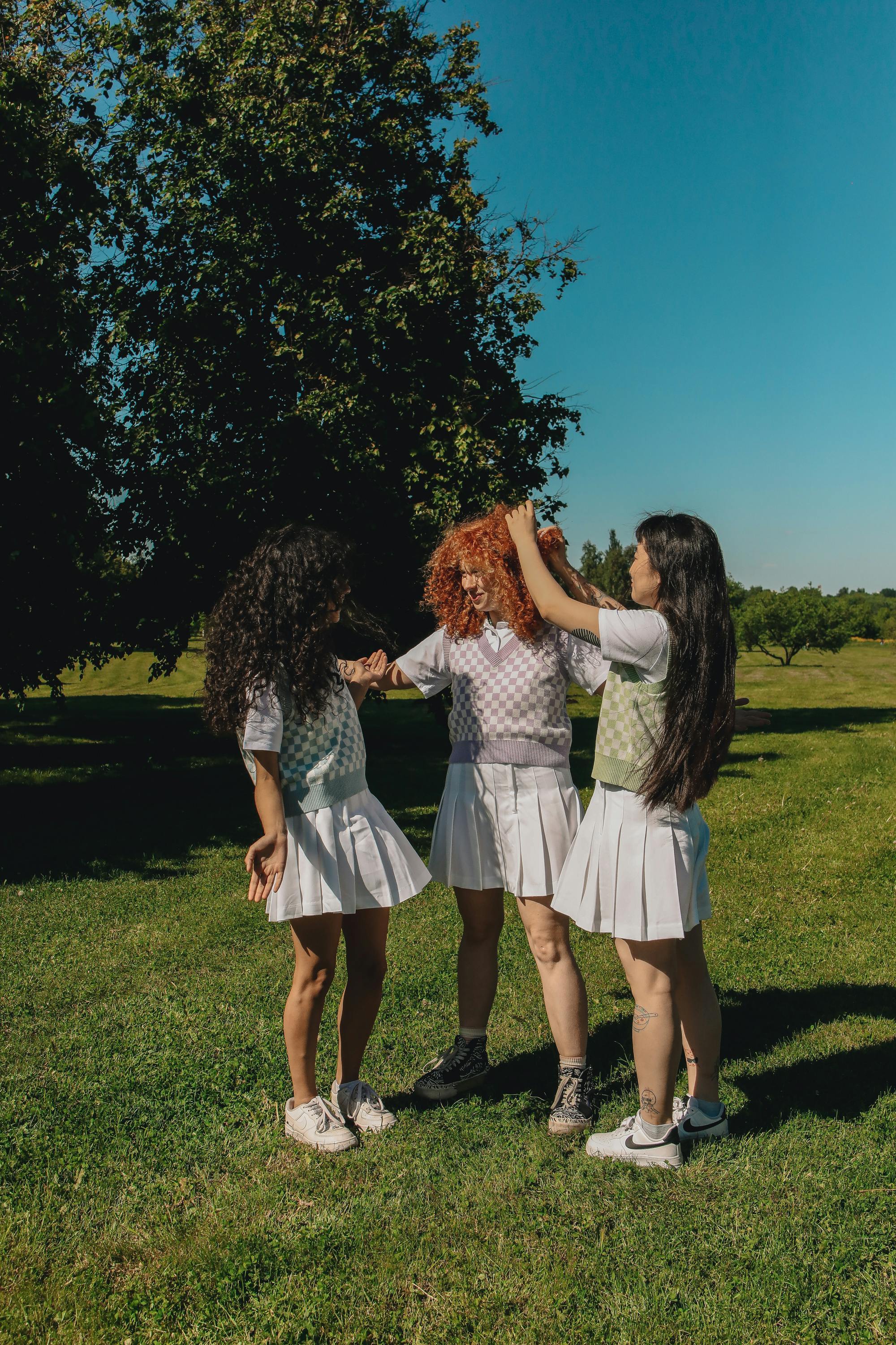 teenage girls standing on green grass field