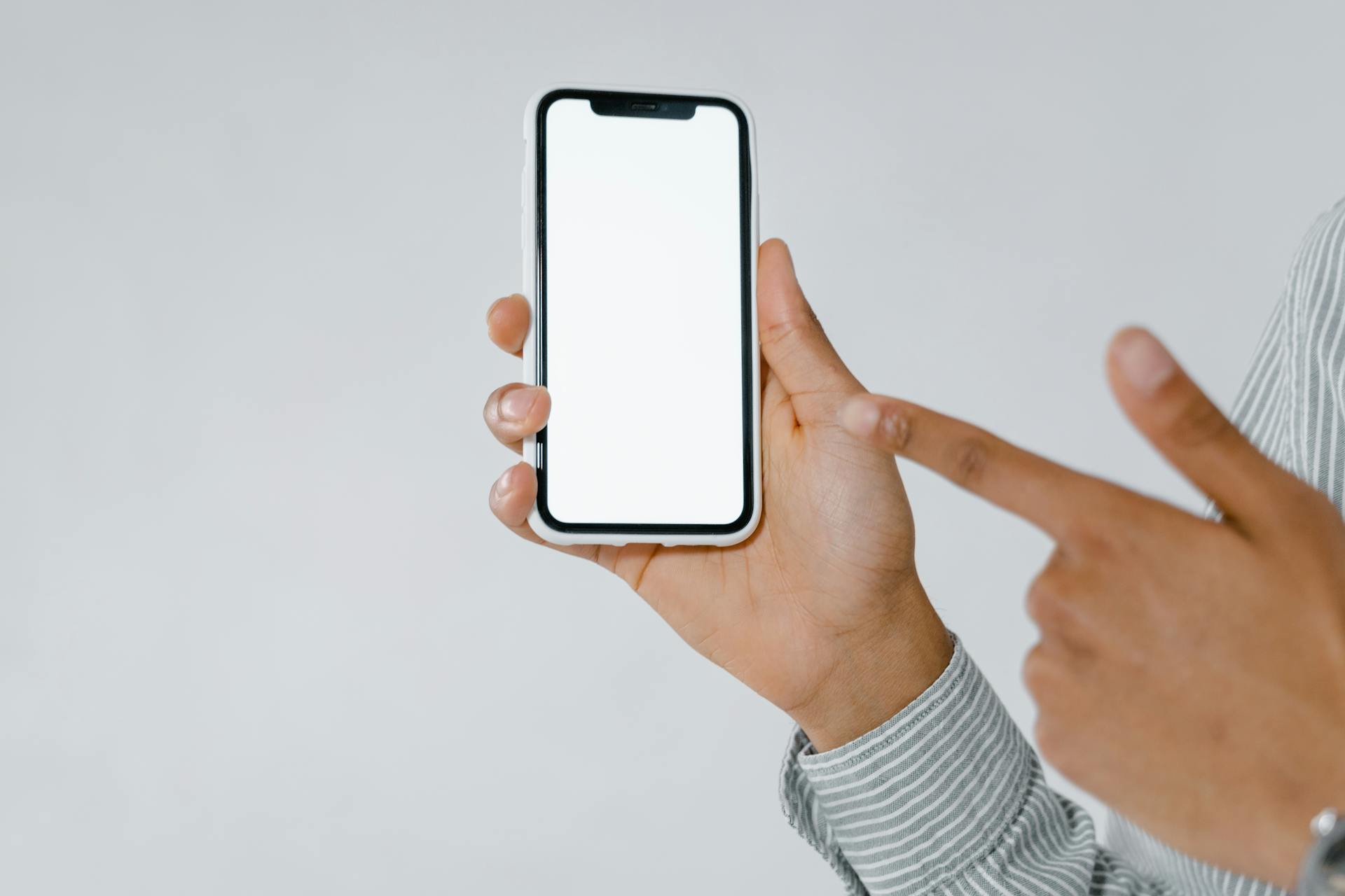 Photo of a Person Pointing at a Cell Phone