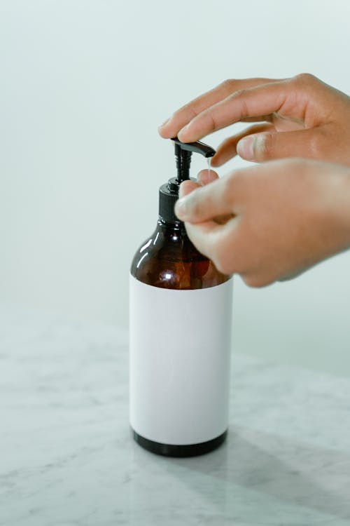 Person Pushing Brown Dispenser 