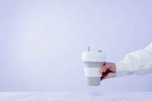 Close-Up Shot of a Person Holding a Collapsible Cup