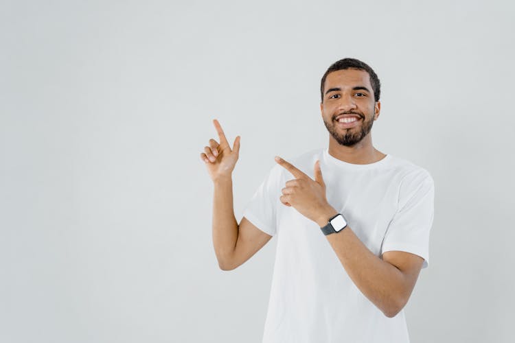 Man In A White Shirt Pointing While Smiling