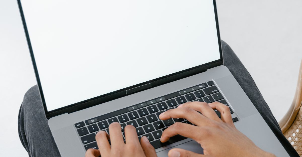A person typing on a laptop from a high angle