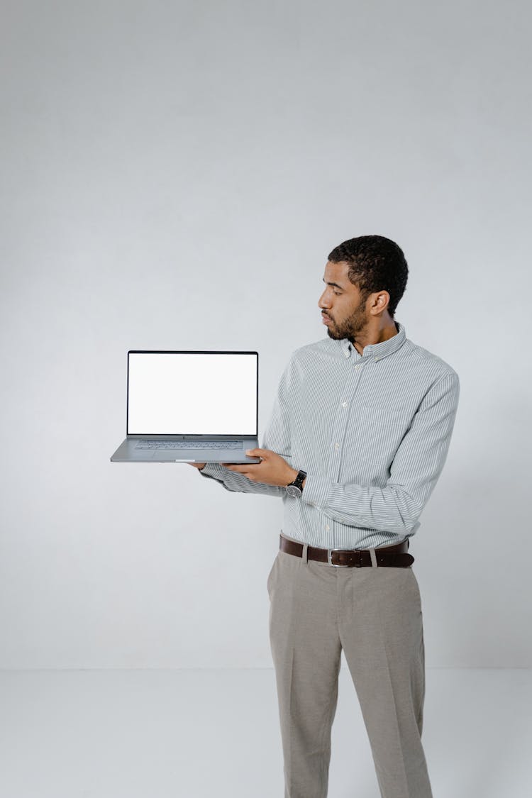 A Man In A Smart Casual Clothing Holding A Laptop