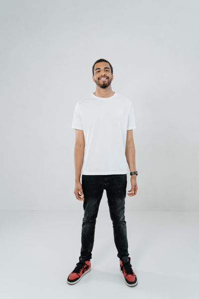 Man in a plain white crew-neck t-shirt and dark jeans — photo by MART PRODUCTION on Pexels