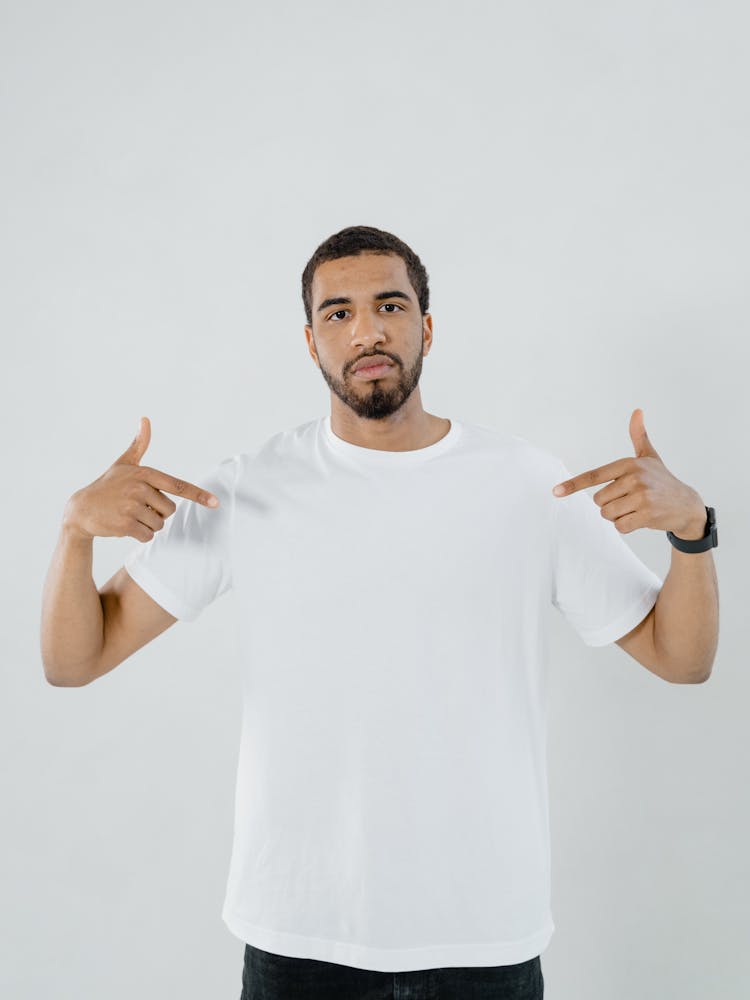 A Bearded Man Pointing At His Plain White Shirt