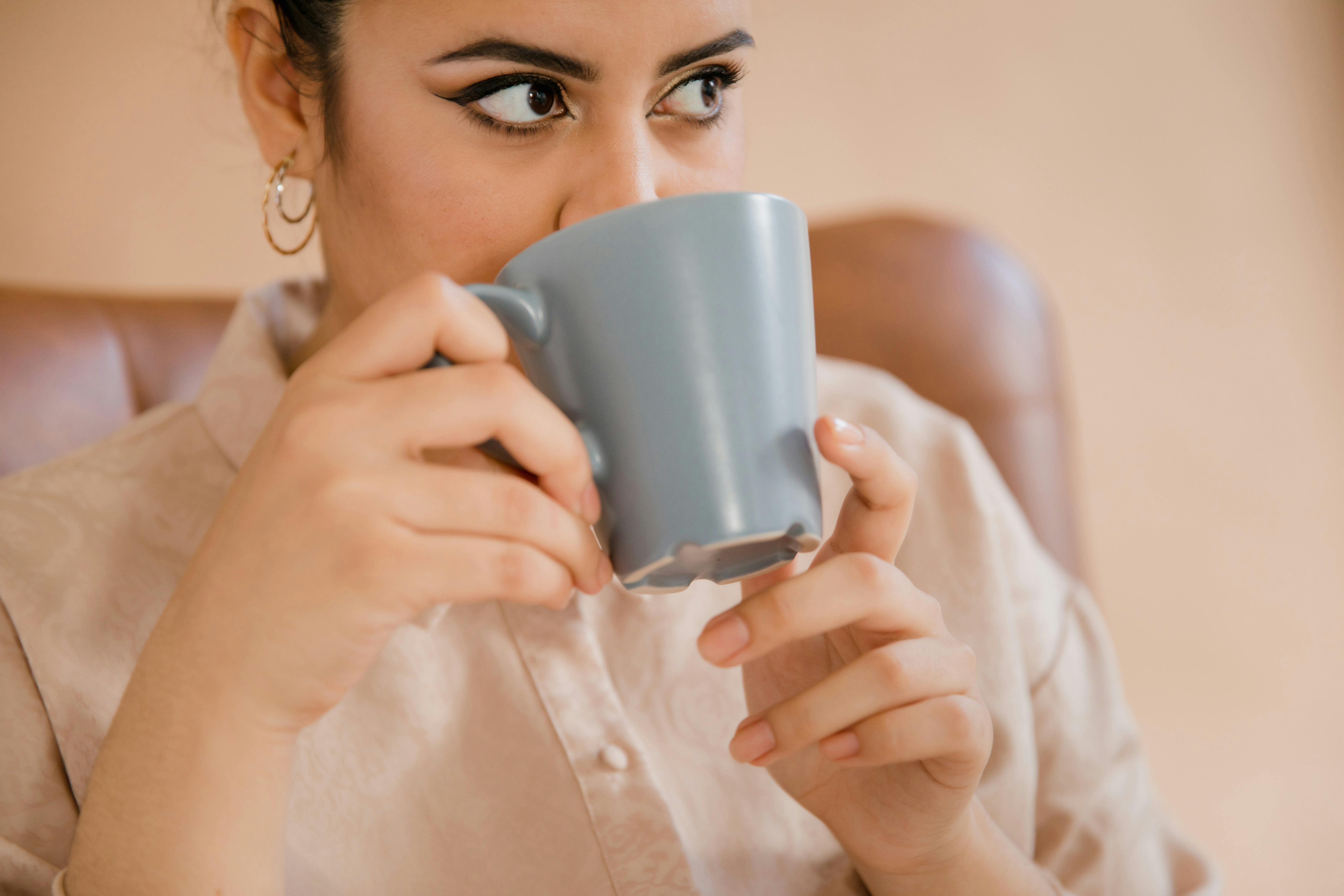 Woman in White Button Up Shirt Holding Gray Ceramic Mug