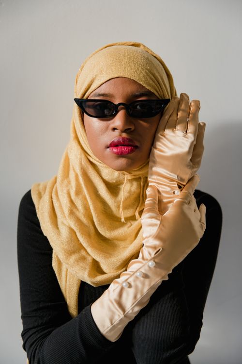 Free Portrait of a Muslim woman wearing a hijab, sunglasses, and elegant gloves, exuding confidence. Stock Photo