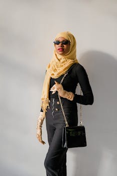 Fashionable woman wearing a hijab, sunglasses, and a chic outfit, exuding elegance.