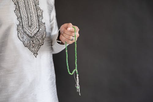 Person Holding Green Prayer Beads