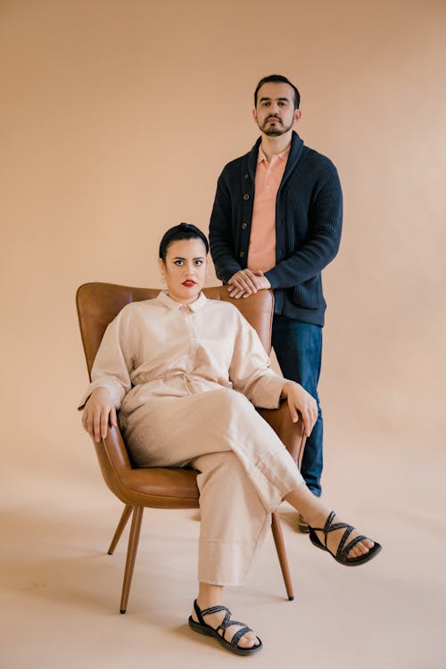 Man Standing Behind a Woman Sitting on a Chair