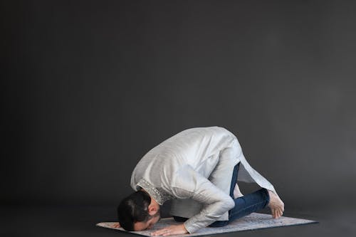 Man in Gray Long Sleeve Shirt and Blue Denim Jeans Kneeling