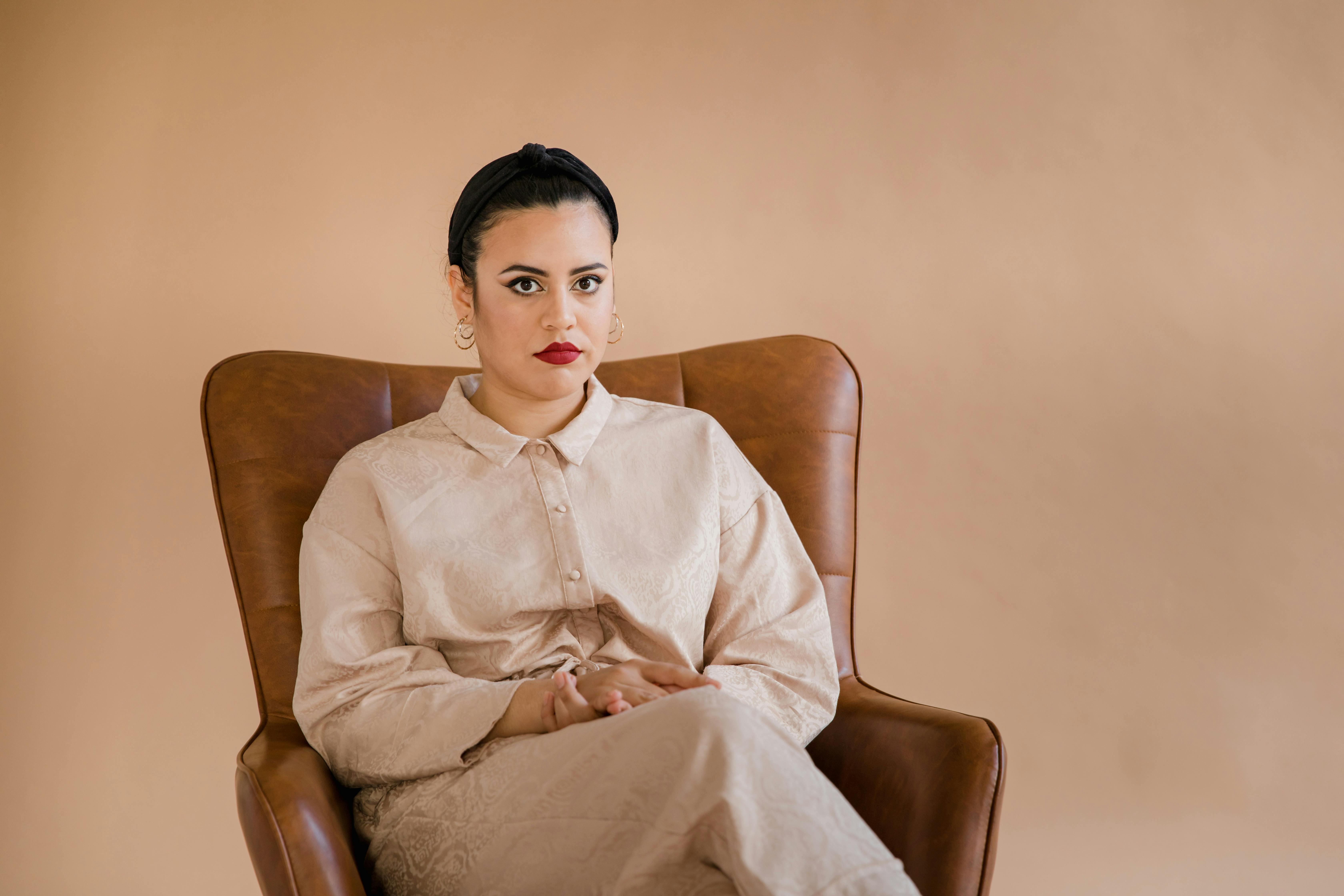 Man in White Dress Shirt Sitting on Brown Sofa Chair