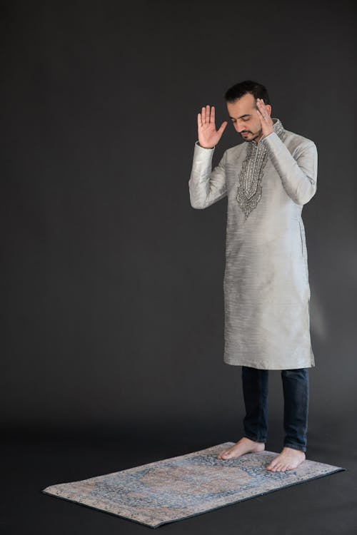 Man Standing on a Carpet Praying