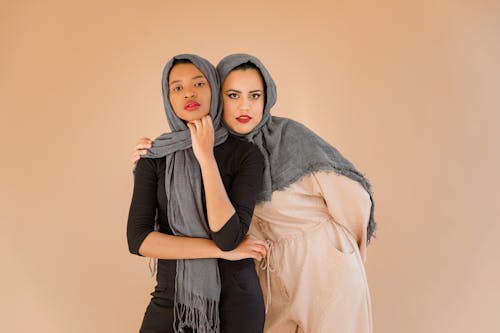 Woman in Gray Hijab and Black Long Sleeve Shirt Beside Another Woman