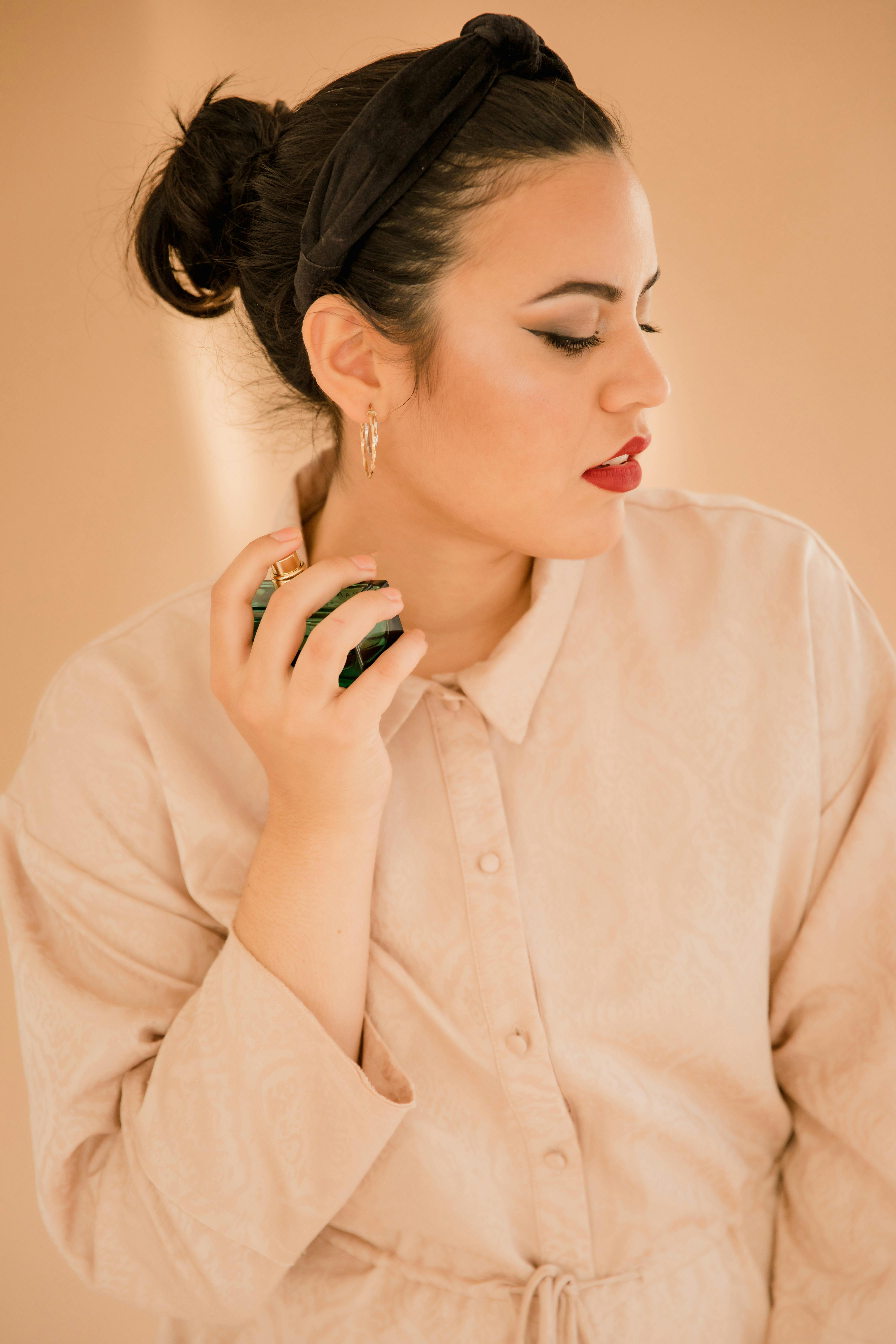 photograph of a woman holding a perfume bottle