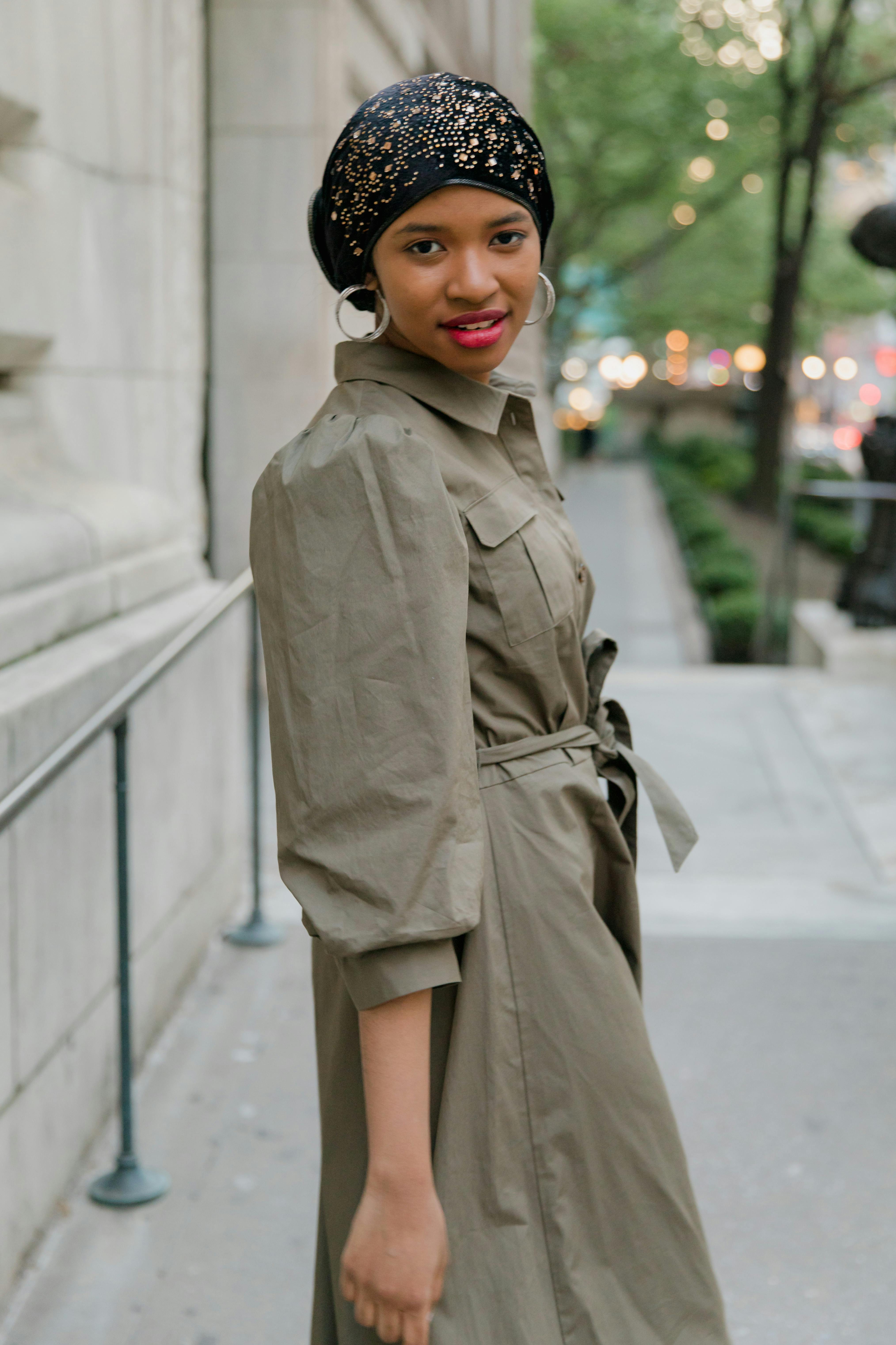 Woman in Brown Coat Standing on Gray Concrete Floor