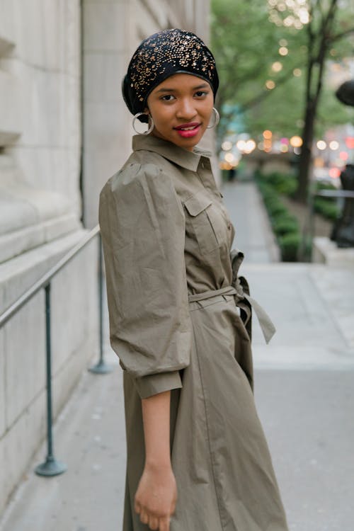 Woman in Brown Coat Standing on Gray Concrete Floor