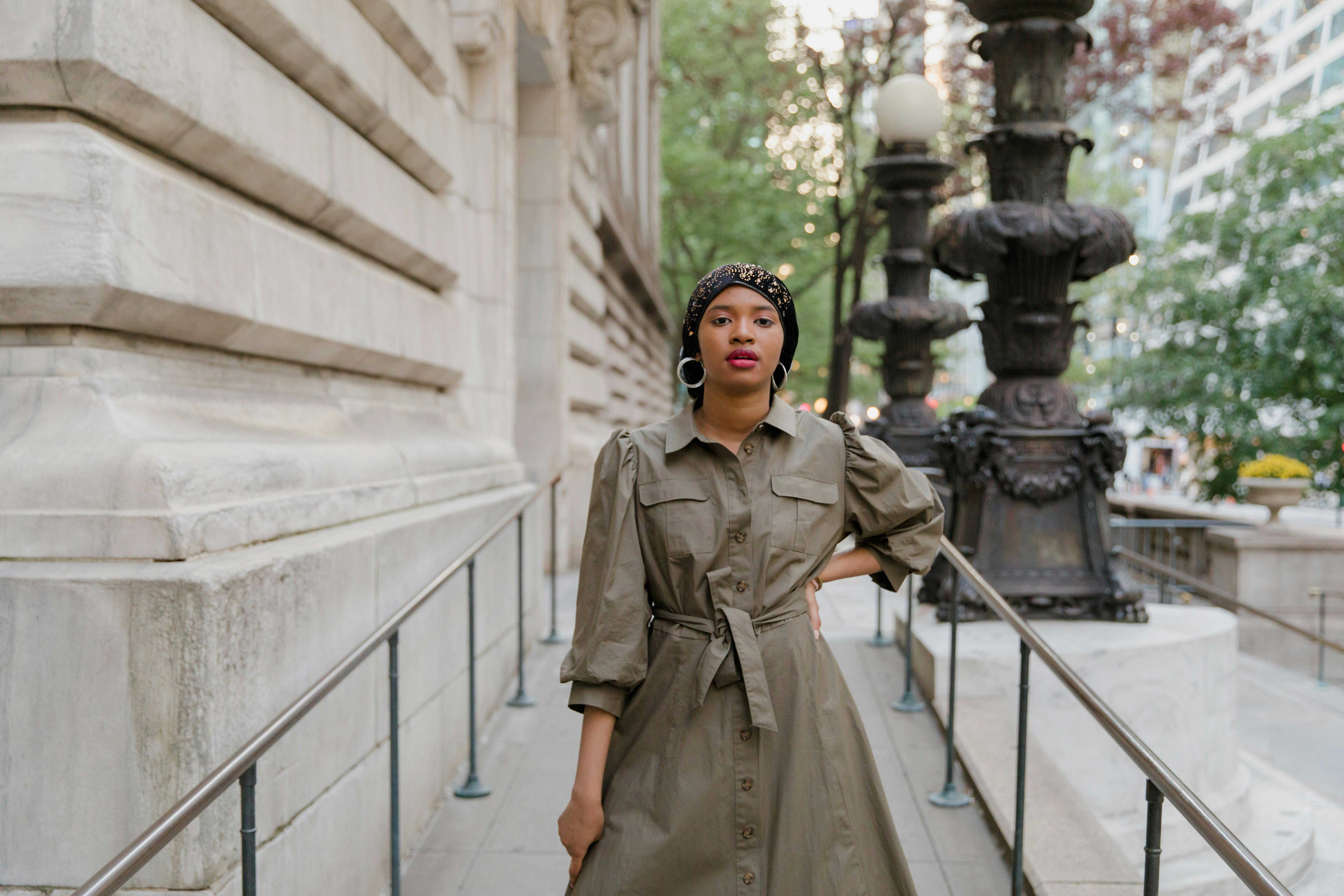 Woman in Brown Coat Standing on White Concrete Staircase