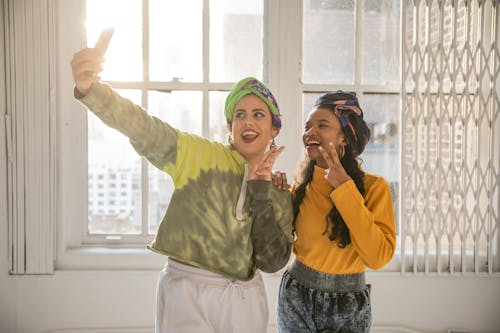 A Woman and a Girl Posing and Taking a Selfie