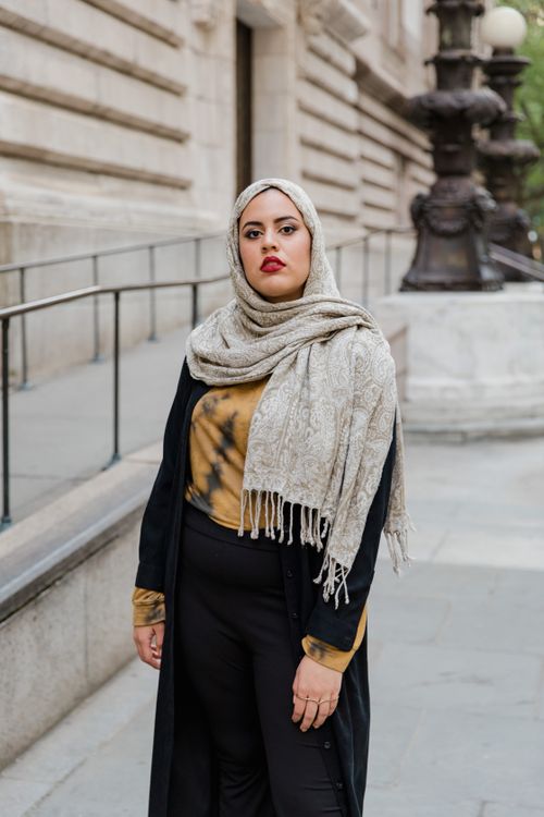 Free Stylish Muslim woman wearing hijab standing confidently on an urban street, showcasing cultural fashion. Stock Photo
