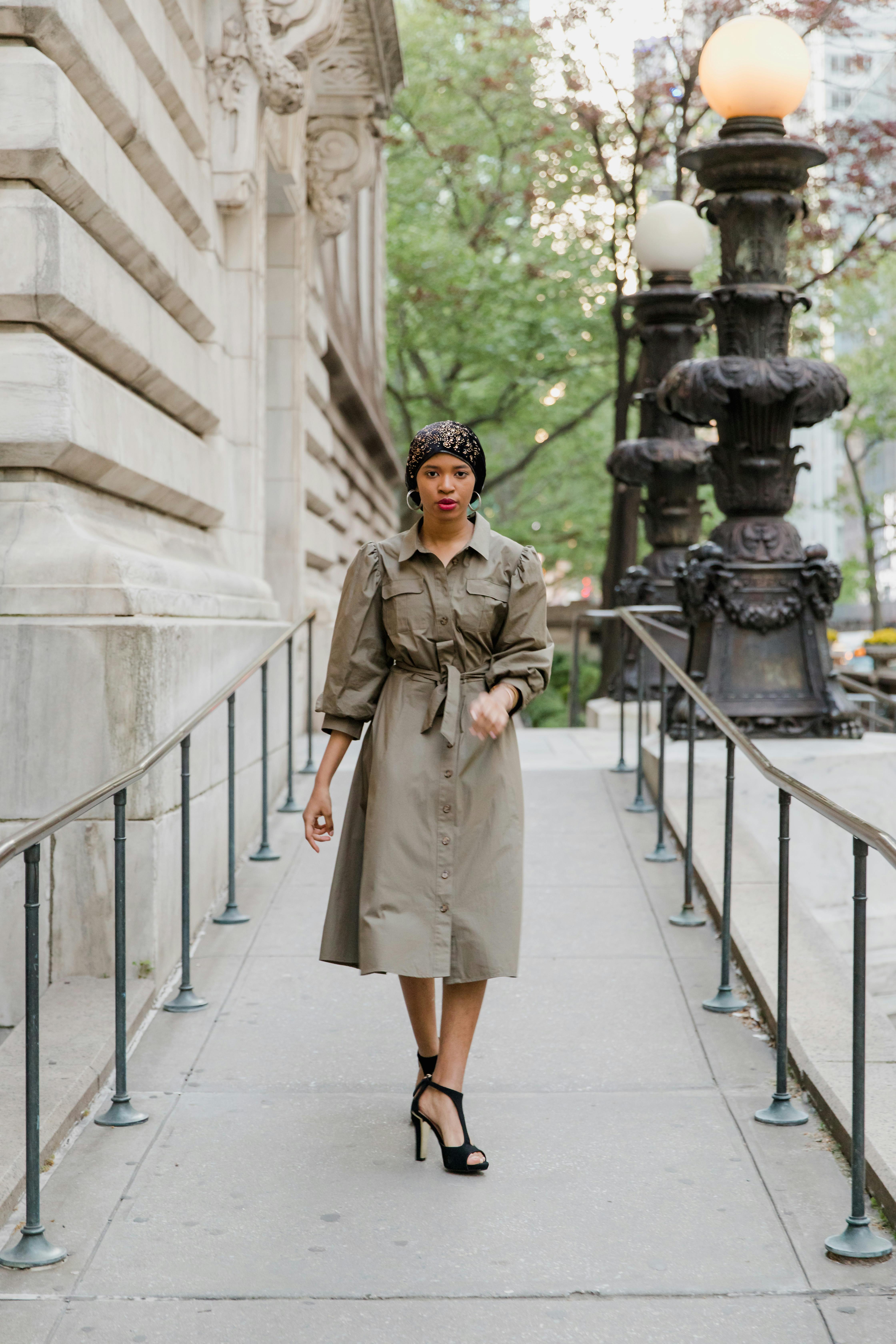 Woman in Brown Coat Standing on Gray Concrete Staircase