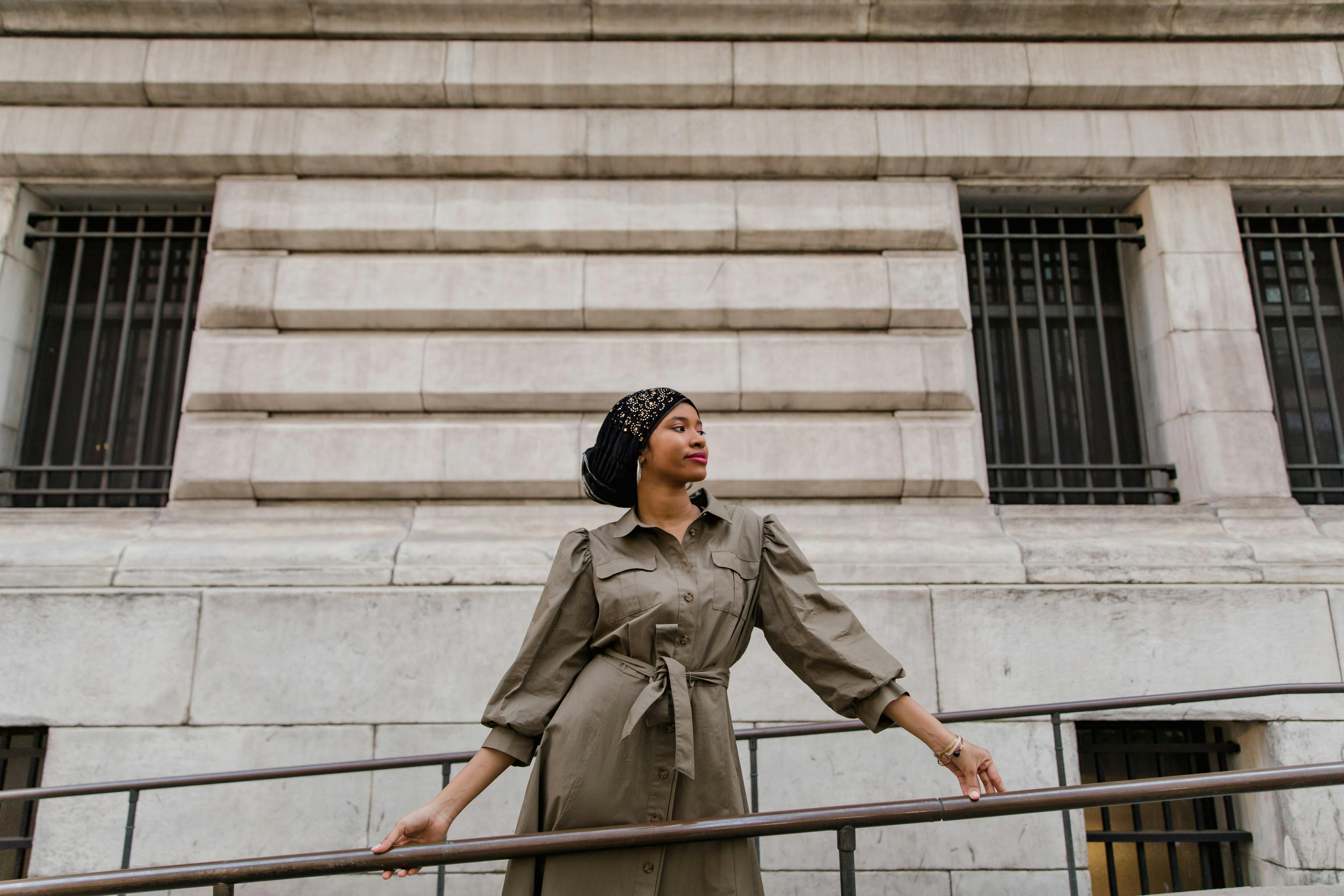 Woman in Brown Coat Standing on Stairs