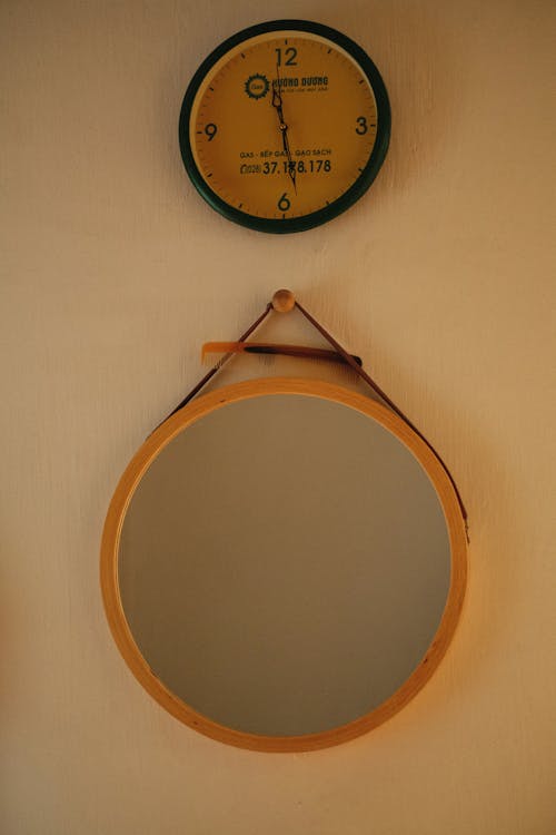 Photo of a Mirror Below a Wall Clock