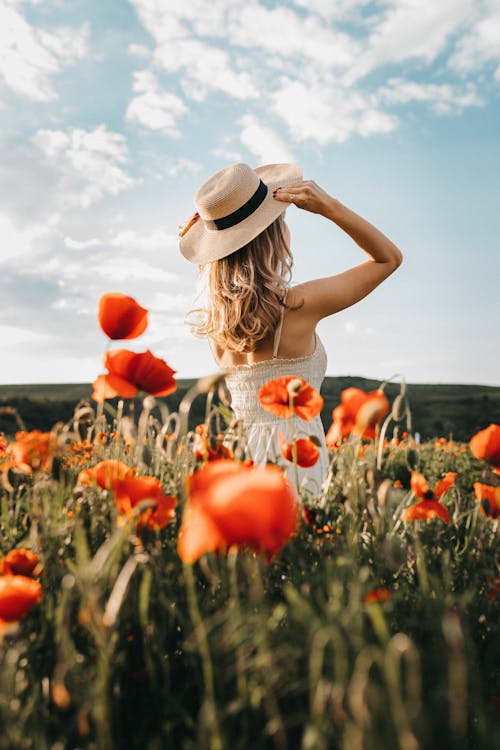 Woman Wearing a Hat Standing on Flower Field