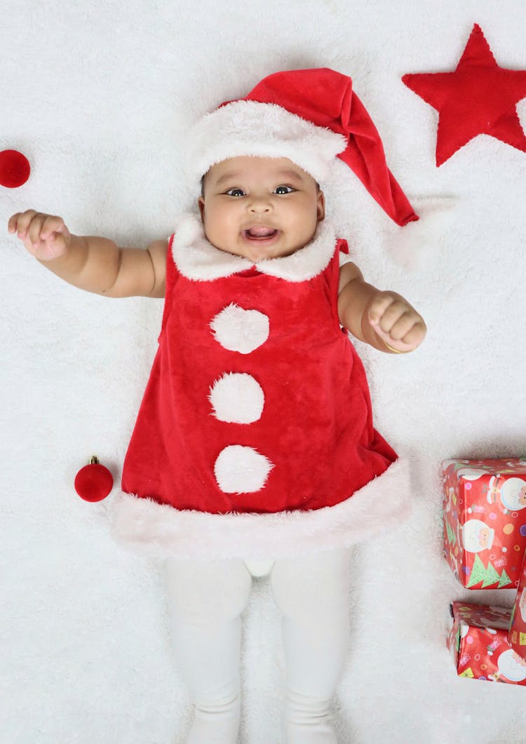 Overhead Shot Of A Baby In A Christmas Themed Outfit