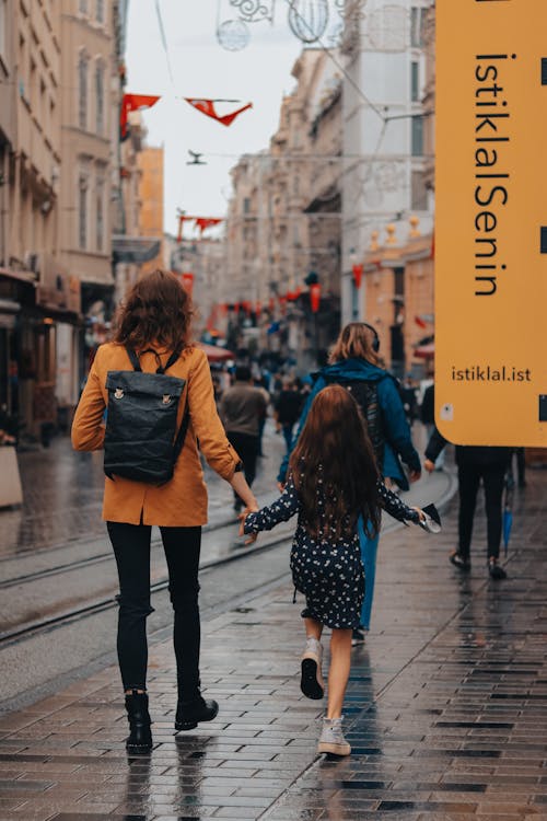 Back View of a Mother and Daughter Walking on a Street